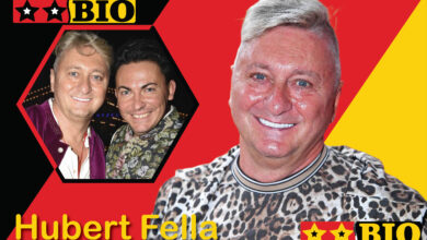 Hubert Fella lächelt neben seinem Ehemann Matthias Mangiapane bei einem offiziellen Event.