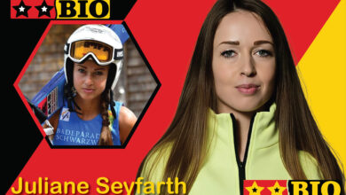 Porträt der deutschen Skispringerin Juliane Seyfarth in professioneller Sportausrüstung mit ihren Sprungskiern vor einer winterlichen Schanzenkulisse